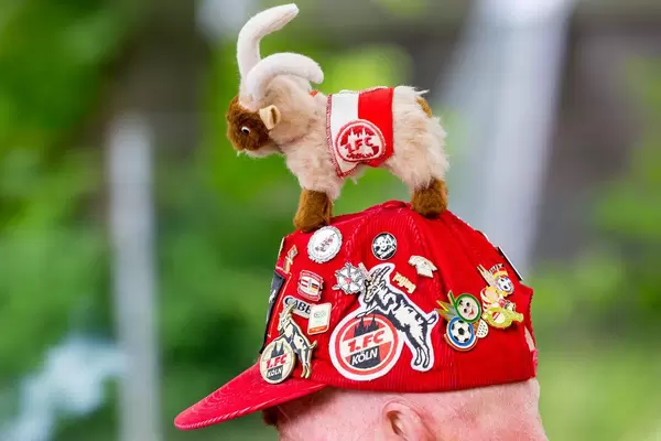 1. FC Köln Mütze eines Fans mit Ansteckern und Hennes (Geißbock)
