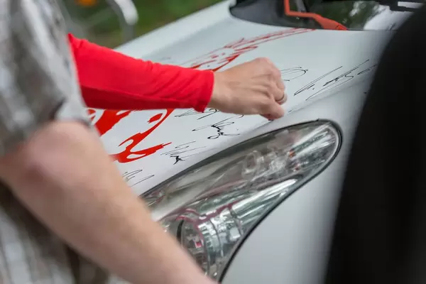 1. FC Köln Spieler signiert ein Auto