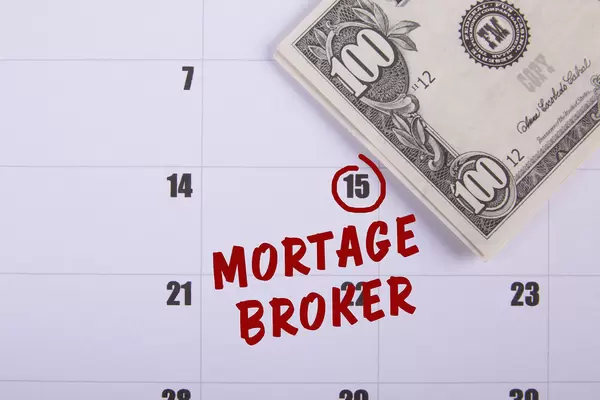 100 dollar banknote and Mortage Broker text on the calendar