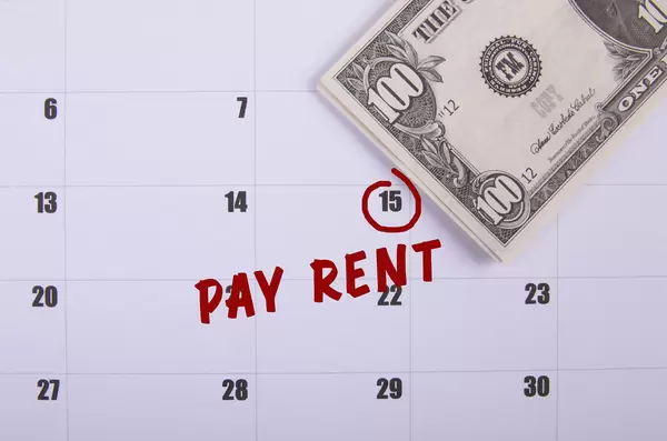 100 dollar banknote and Pay Rent text on the calendar