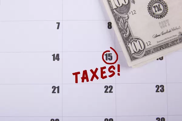 100 dollar banknote and Taxes date marked on the calendar