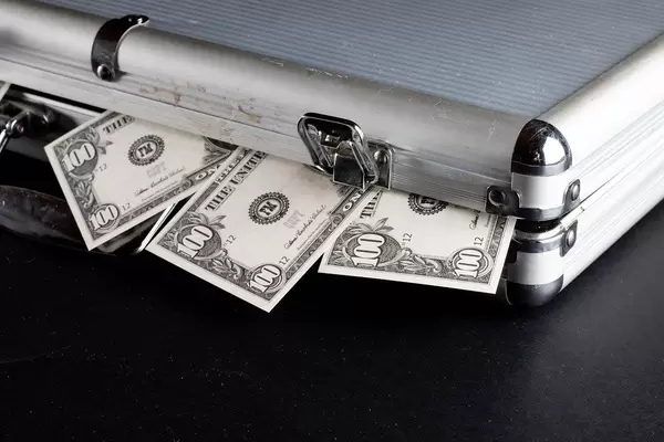 100 Dollar Noten gucken aus einem Geldkoffer heraus