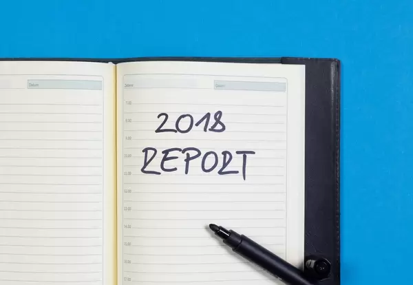 2018 Report - Bericht des Jahres 2018 auf einem Notizbuch mit schwarzem Pfilzstift geschrieben