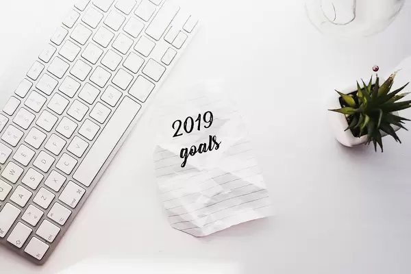 2019 goals flatlay in an office setting with keyboard and plant on a white background
