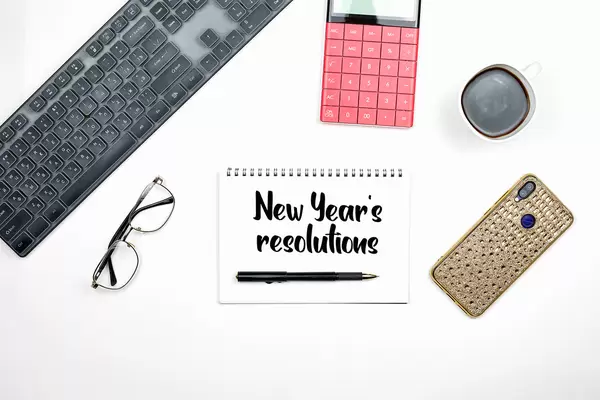 2021 new year resolution text on notepad with office accessories