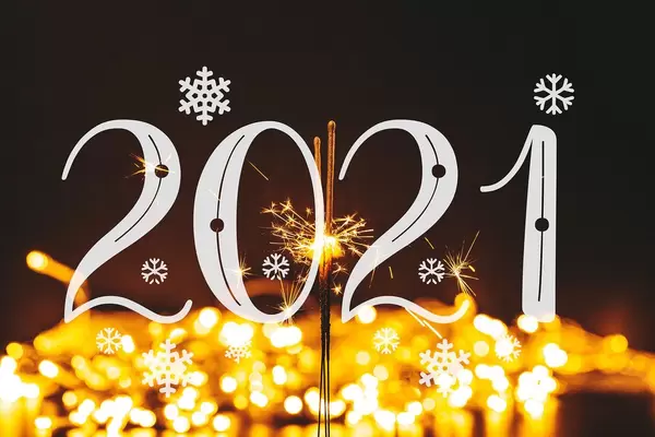 2021 on bright background bokeh garlands with sparklers