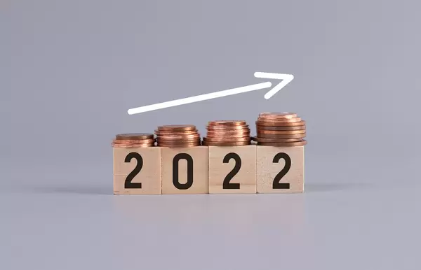 2022 text on wooden blocks with coins and up arrow