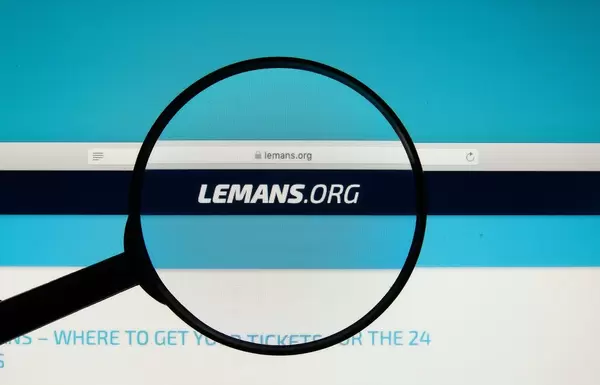 24 Hours of Le Mans official website on a computer screen with a magnifying glass