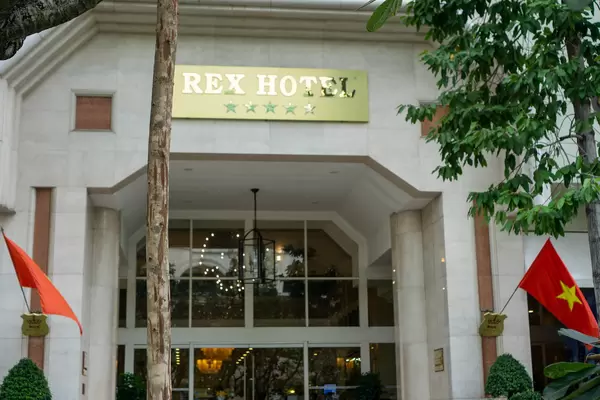 5 Star Rex Hotel Entrance at Nguyen Hue Walking Street with Vietnamese Flags in Ho Chi Minh City, Vietnam