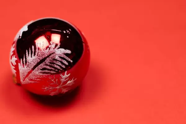 A big Christmas tree ball on a red background
