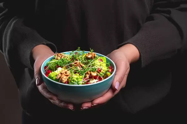 A bowl of fresh healthy food in women's hands (Flip 2020)