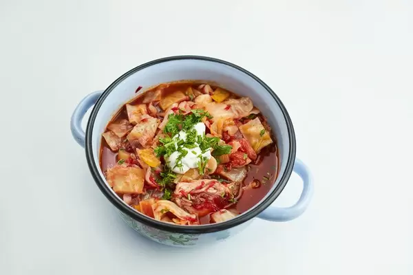 A bowl of fresh vegetable soup with sour cream and herbs