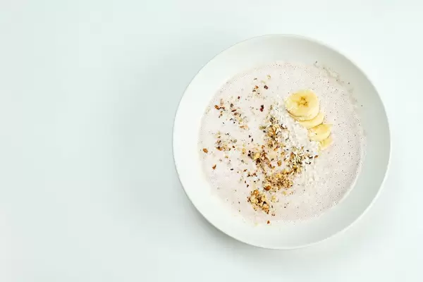 A bowl of refreshing oats and banana based smoothie with walnut shreds