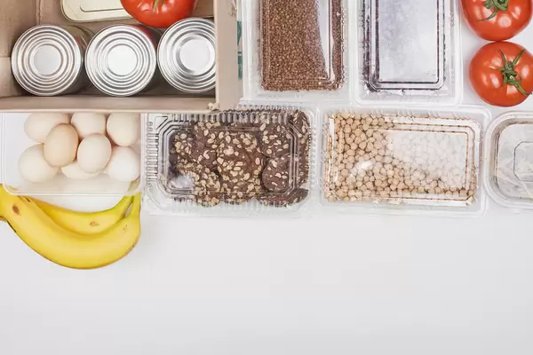 A box for those in need: bananas, eggs, cookies, nuts, tomatoes and tin cans from a food bank
