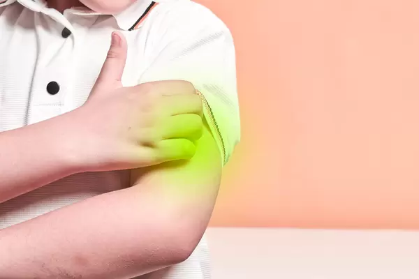 A boy scratching his hand