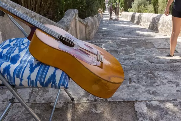 A busker's guitar and three sculptures by Joan Bennàssar on the Carrer del Calvari steps, Pollença