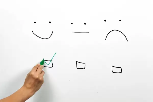 A client checking smiley face box on the whiteboard. Service rating, satisfaction, customer experience concepts