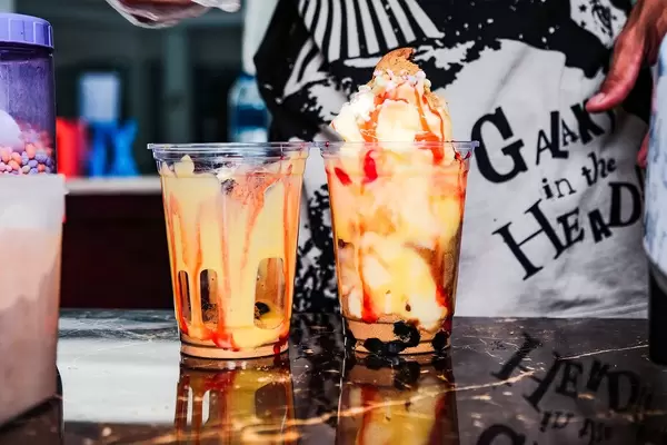 A cup filled with mango flavored shake