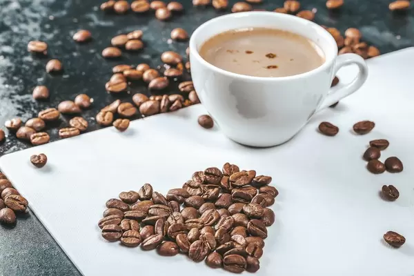 A Cup of fresh coffee with coffee beans on the table