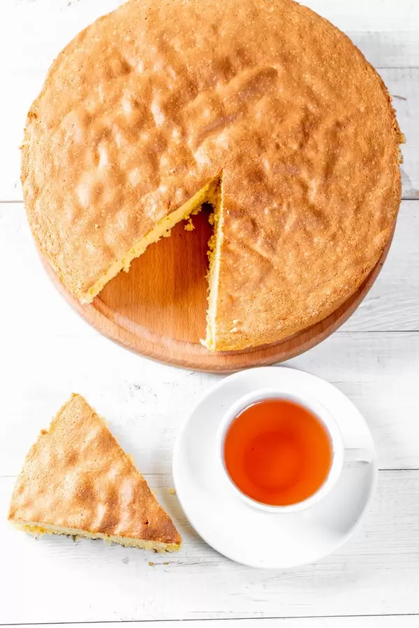 A Cup of tea and a fresh baked biscuit on a white wooden table