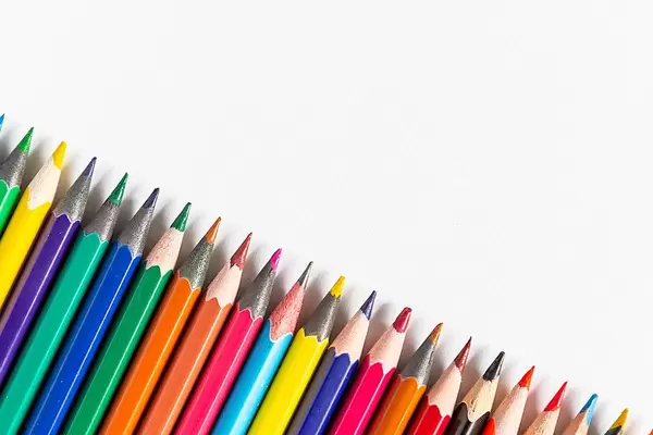 A diagonal row of colored pencils on white paper