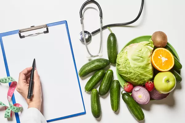 A dietician writing healthy dieting prescriptions on the paper