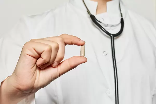 A doctor hand holds a pill