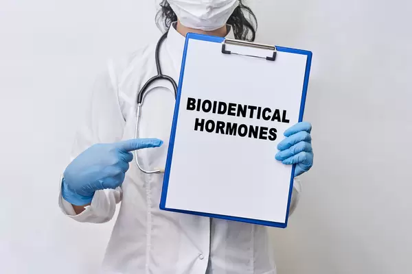 A doctor holds a paper card with text - Bioidentical hormones