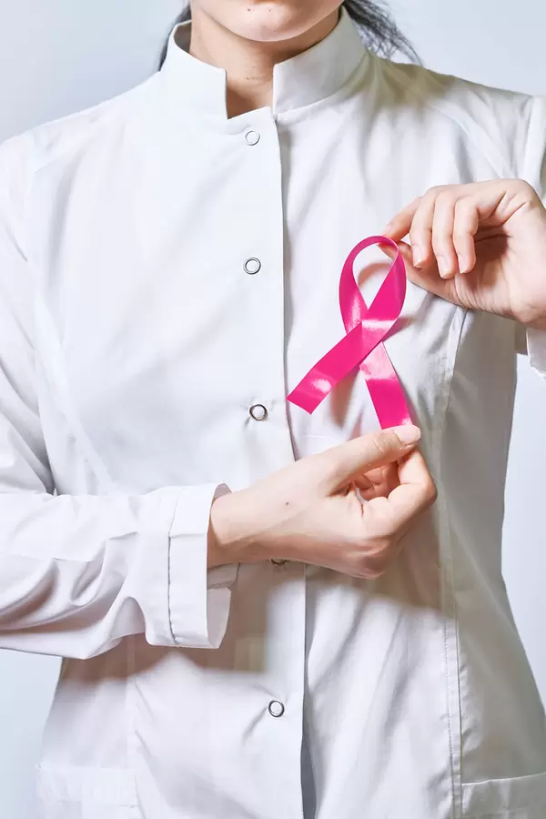 A doctor with a purple ribbon pinned in the flap of white coat