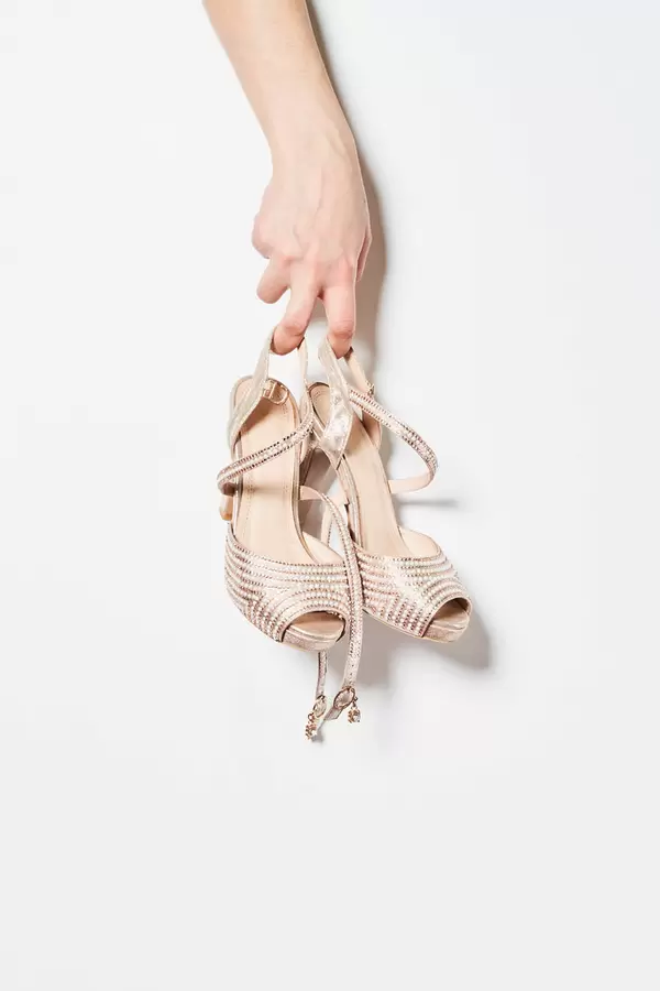 A female hand holding stylish shoes