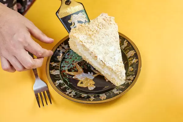 A female putting sliced piece of tasty cake on the plate