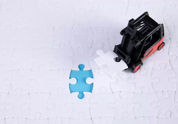 A forklift truck picks up the missing puzzle piece
