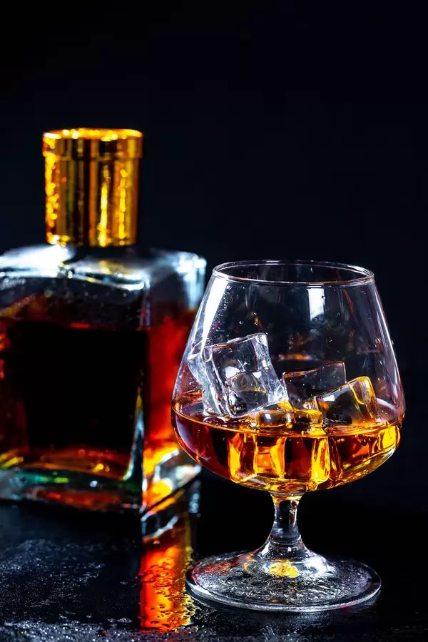 A glass of brandy with a bottle