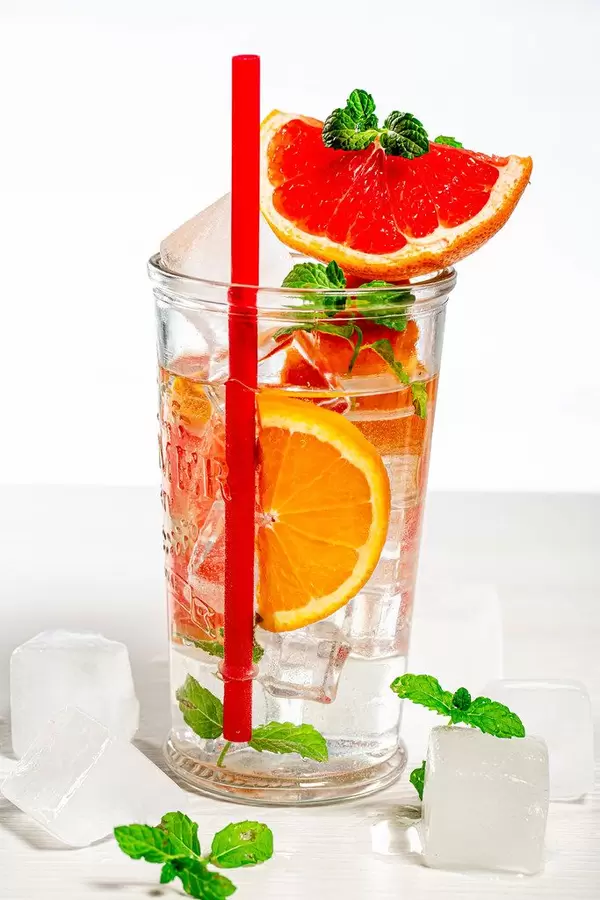 A glass of cold citrus lemonade with fresh fruit