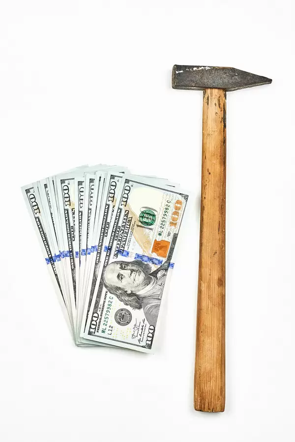 A hammer and money on white