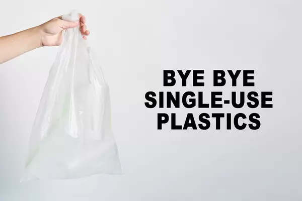 A hand holds a bag of plastics - bye-bye single-use plastics