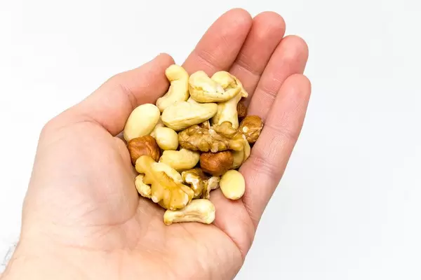 A handful of different nuts such as walnuts, cashew nuts, almonds and hazelnuts