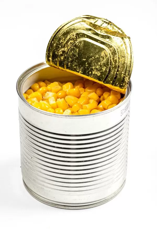 A jar metal can with sweet corn on white