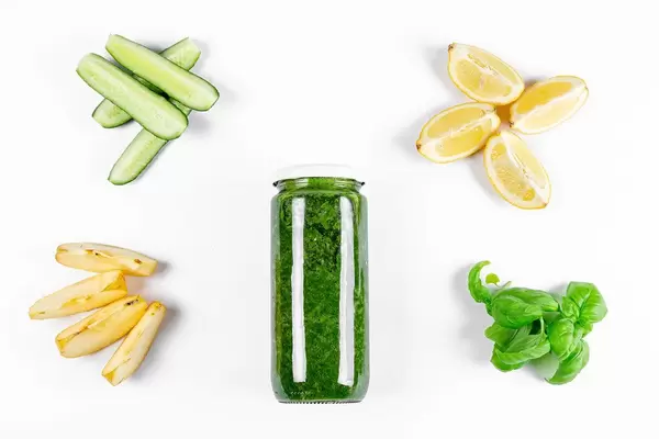A jar of healthy smoothies in a jar on a white background with ingredients