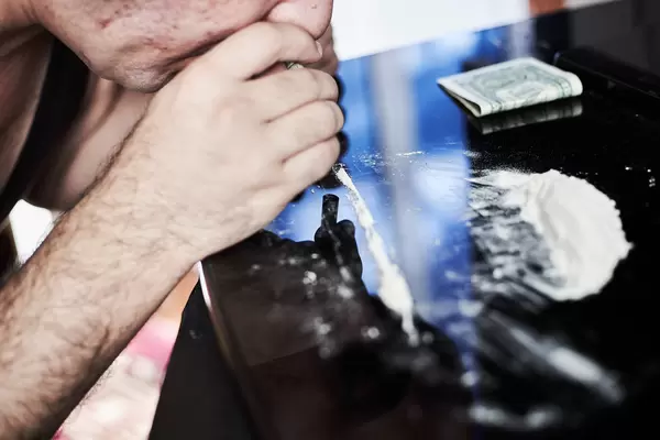 A junkie man snorting cocaine