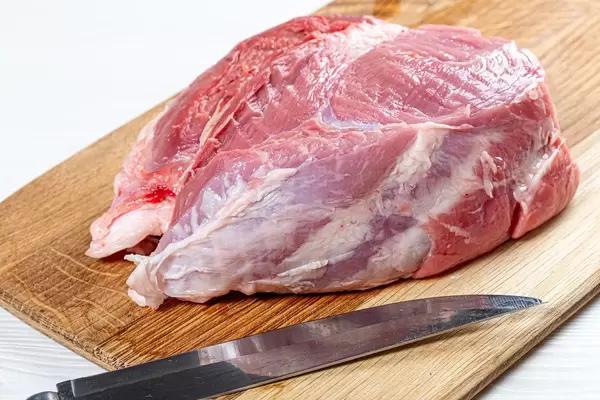 A large raw piece of pork with a knife (Flip 2019)