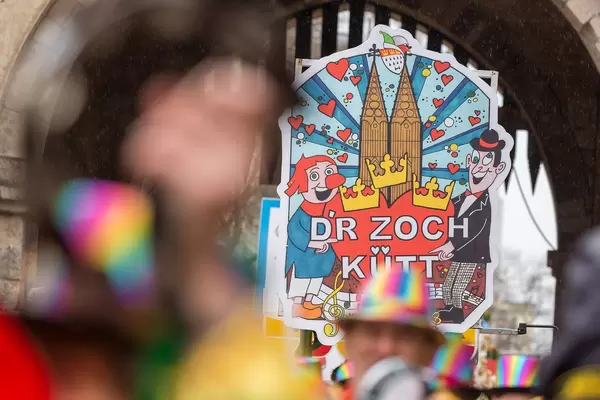 A large sign announces the arrival of the Rose Monday Parade at Severinstorburg in Cologne: "D'r Zoch kütt", Colognian or Kölsch dialect for "the parade comes"