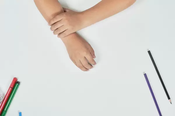 A little boy at drawing class. Hands of kid on white board. View from above