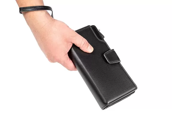 A man holds a black wallet in his hand