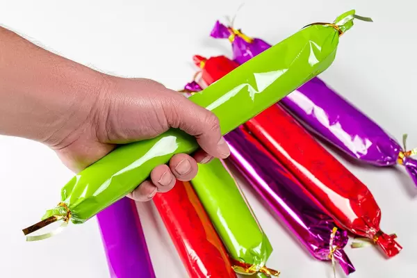 A man holds a large candy in his hand, close-up (Flip 2020)