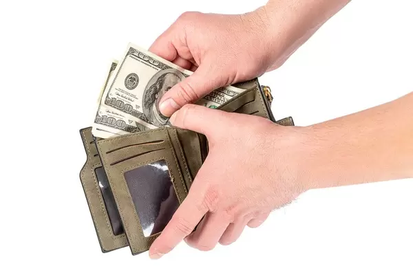 A-man-puts-dollars-in-an-open-wallet.jpg