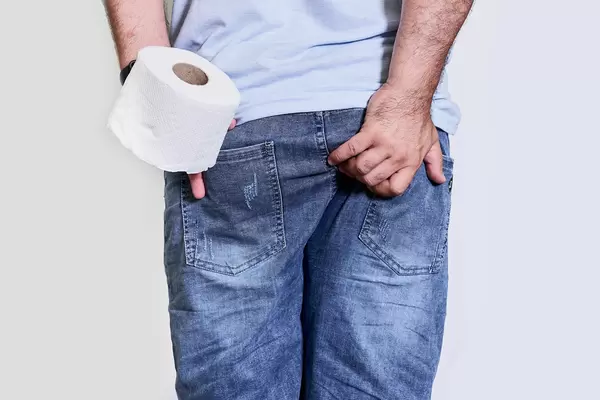 A man suffers from diarrhea and holds toilet paper roll