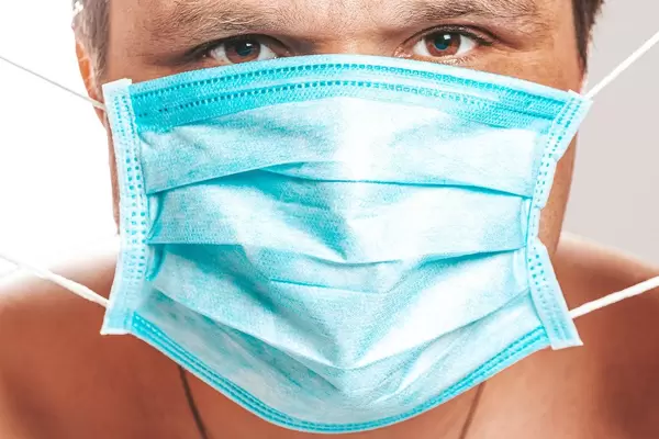 A man with a medical mask on his face close up