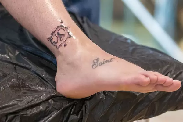 A participant gets a tattoo of a pretzel to mark attendance at the Bits & Pretzels start-up conference taking place in Munich during the Oktoberfest