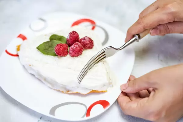 A person cutting sweet carrot cake
